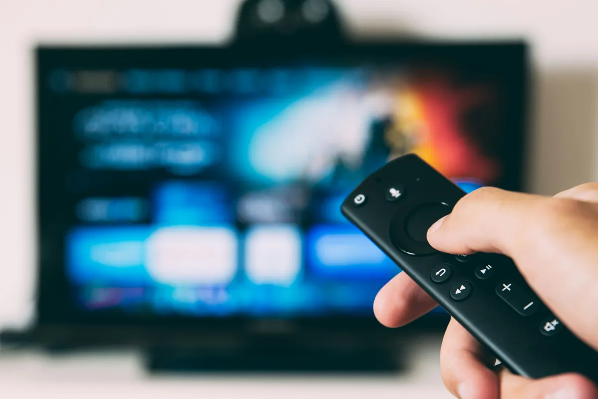 Flat screen television switched on in a dim living room