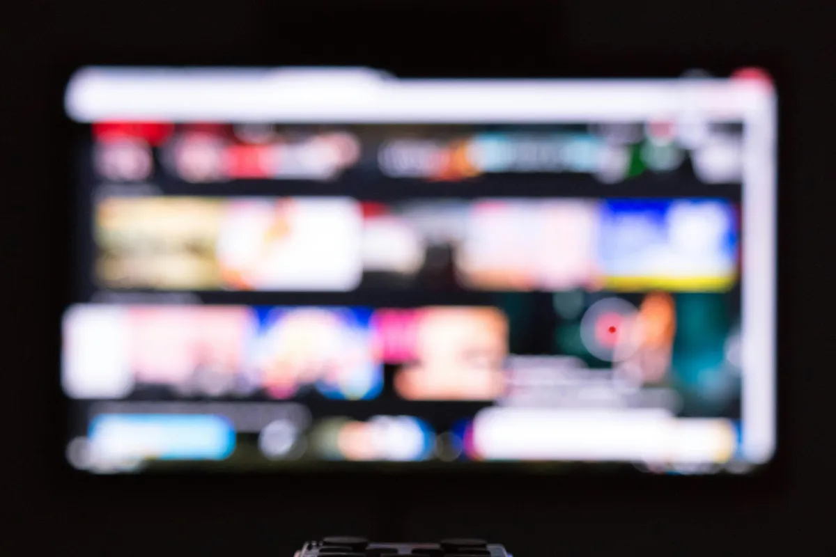 Remote control resting in front of a switched off television