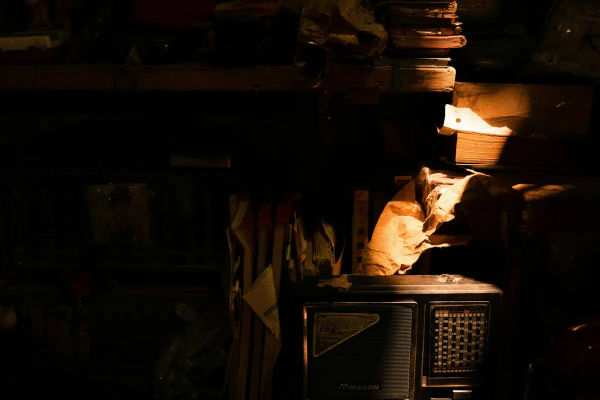 Dimly lit room with an old set standing among stacked clutter
