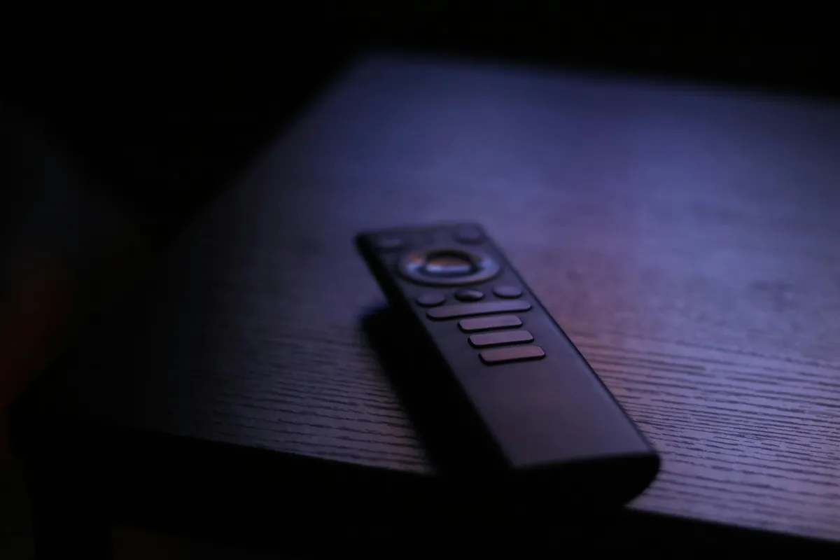 Remote control lying on a table in a softly lit room