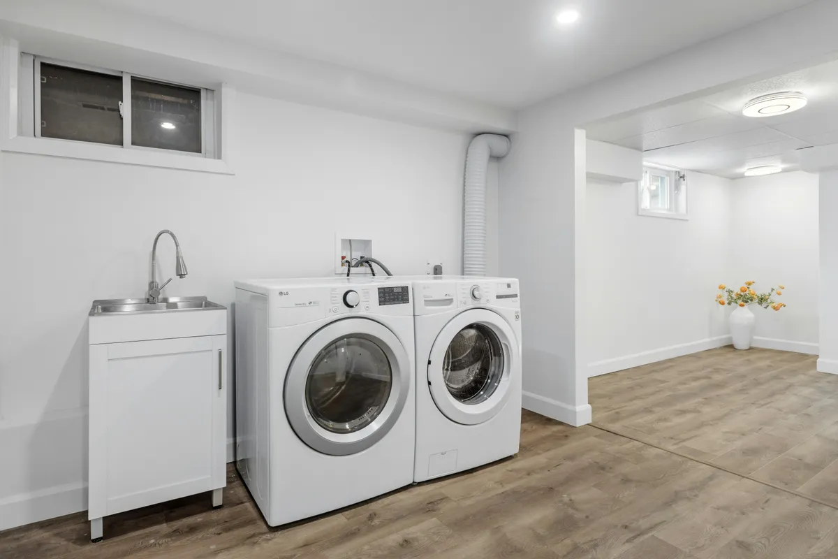 Laundry room with a washer and dryer standing side by side