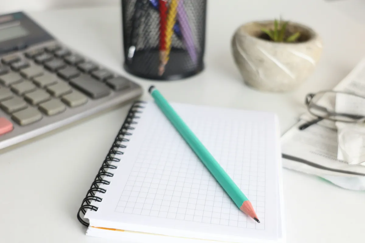 Desk with a calculator, open notebook and pencil for adding up an insulation quote
