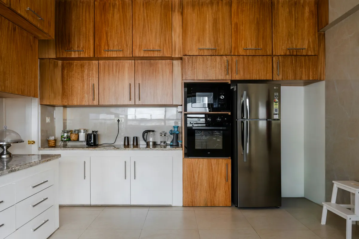 Kitchen with white cabinets and a dark refrigerator