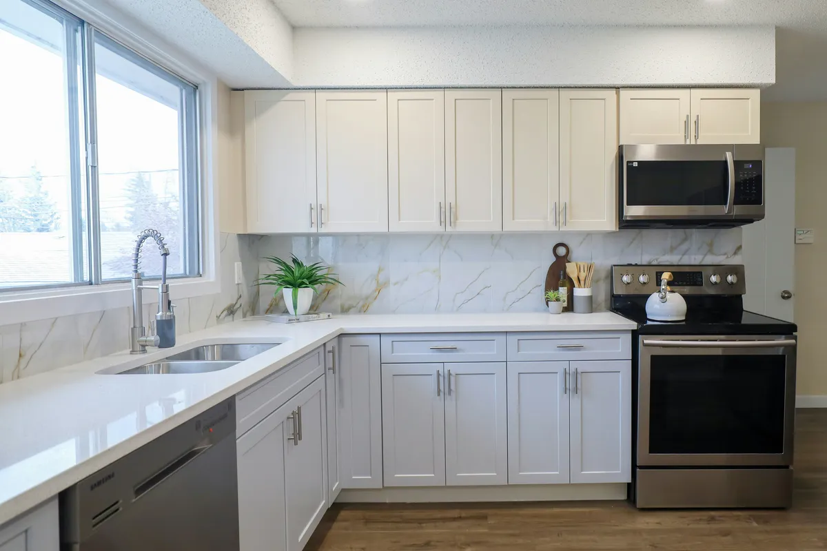 Modern kitchen with white cabinets and stainless steel appliances