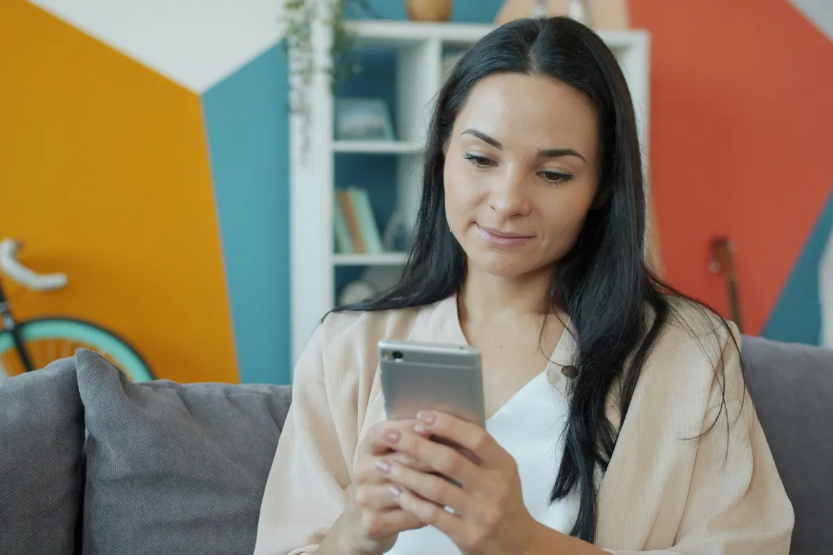 Person on a sofa checking an app on a phone