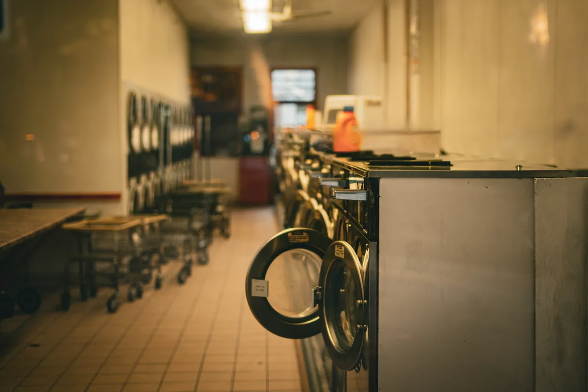 Row of front loading washers lined up along a wall
