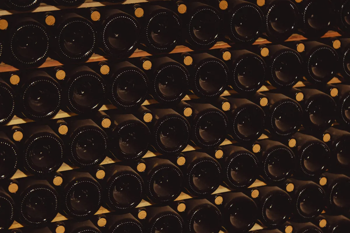 Rows of dark glass wine bottles stacked on shelves