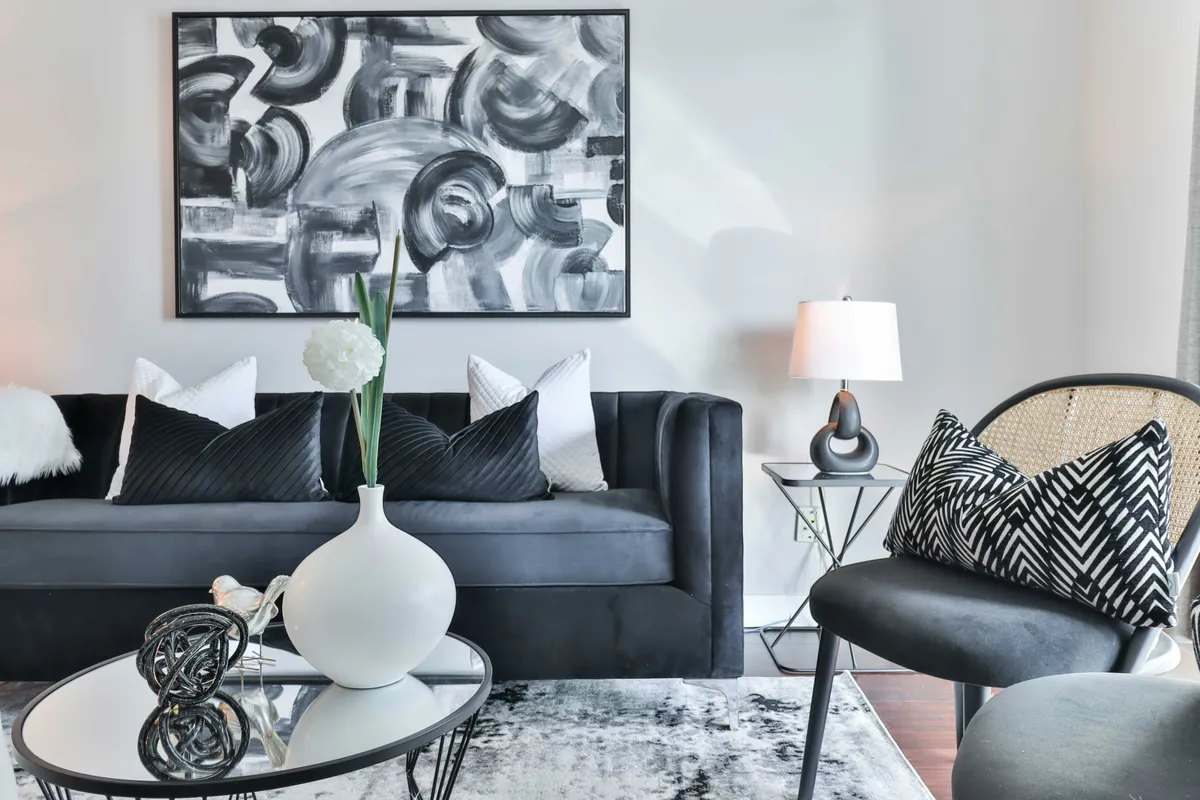 Living room with a dark couch and a vase of flowers on a table