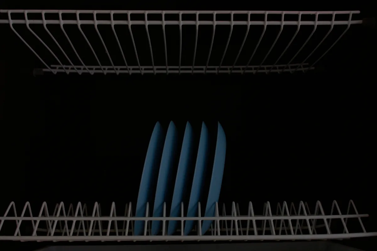 Close view of plates standing in a kitchen dish rack