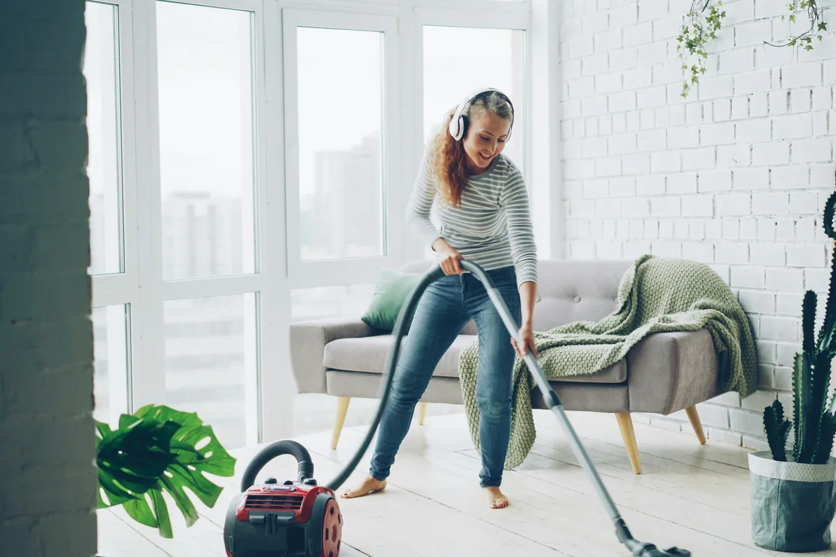 Person running a vacuum over a floor at home